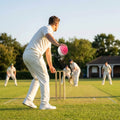 Cricket training ball with reverse swing capability, in red/white and pink/white